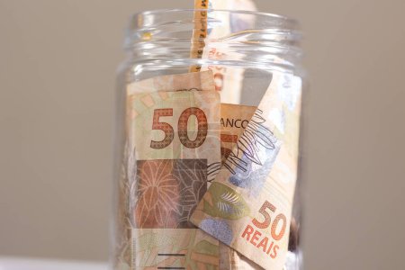 Close-up view of Brazilian Real Banknote in glass jar. Brazilian economy.