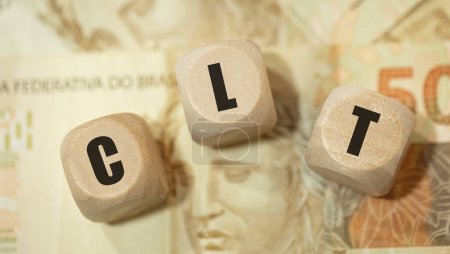  acronym CLT for Consolidation of Labor Laws in Brazilian Portuguese written on wooden dice