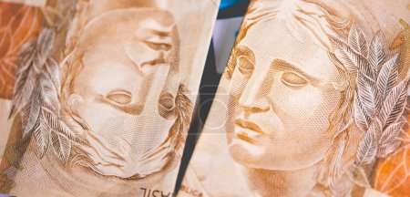 Foto de 50 billetes reales brasileños en una calculadora azul. Dinero, Brasil, Impuesto sobre la Renta. - Imagen libre de derechos