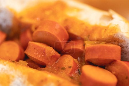 Foto de Perro caliente de estilo brasileño con salsa de tomate y salchicha cortada en rodajas. - Imagen libre de derechos