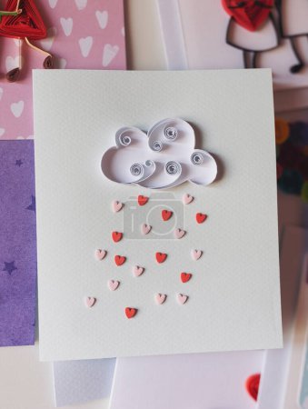 Quilling card with cloud and hearts rain. Love concept. Happy valentine day, dating,romantic or wedding. Gift, message for lover. Hand made of paper quilling technique. Hobby, home office. scrapbook