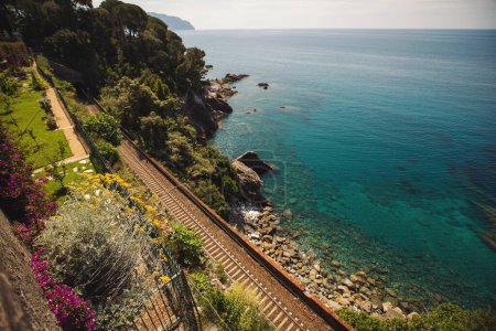 Nervi Train Station, Liguria, Italy . It offers spectacular views, as it sits directly on the coast overlooking the Mediterranean sea. Railway line and train near emerald blue sea.