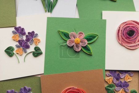 Quilling-Karte mit Blumen. Grußkarten basteln. Schöne Blumenmuster. Papierquilten, bunte Papierblumen. Handarbeit aus Papier Quilling-Technik. Handwerk zu Hause. Hobby, home office.