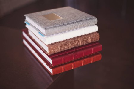 Photo for A pile of books. multi-colored albums of different sizes and textures on a dark background. - Royalty Free Image