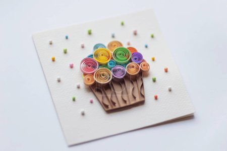 Paper Cupcake Quilling Paper Art auf weißem Hintergrund. Leckere Cupcakes für Party, Geburtstag. Ansicht von oben. Handarbeit aus Papier Quilling-Technik. Handwerk zu Hause, Kartenbasteln, Geschäftskonzept.