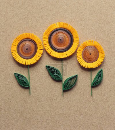 Quilling-Karte mit Sonnenblumen auf braunem Papier Hintergrund. Sommerblumen. Handgefertigt aus Grußkarten in Papierquilttechnik. Handwerk zu Hause. Hobby, home office.