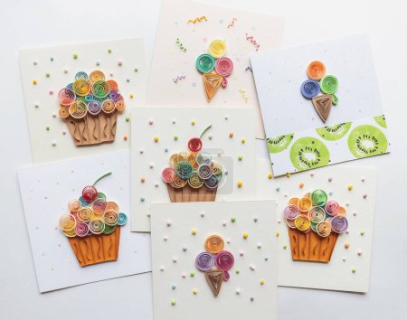 quilling cards with Paper cupcakes. Delicious Cupcakes for party, birthday. making greeting cards. Paper quilling. Hand made of paper quilling technique. Handicraft at home. Hobby, home office.
