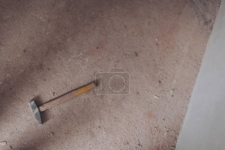 Steel hammer on concrete floor. Strong hammer with wooden handle. Vintage of hammer put on cement floor for background.