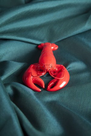 Photo for A lobster  on a green wavy fabric background. Minimal color still life photography. - Royalty Free Image