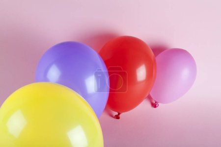 Téléchargez les photos : Ballons aux couleurs harmonieuses sur fond rose. Photographie minime couleur nature morte. - en image libre de droit