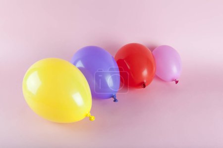 Téléchargez les photos : Ballons aux couleurs harmonieuses sur fond rose. Photographie minime couleur nature morte. - en image libre de droit