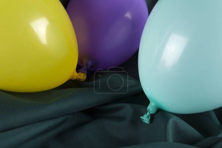 Téléchargez les photos : Ballons aux couleurs harmonieuses sur fond vert ondulé. Photographie minime couleur nature morte. - en image libre de droit