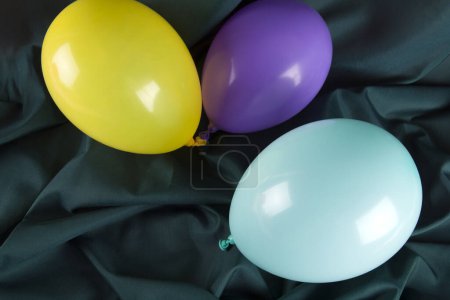 Photo for Balloons in harmonious colors on a wavy green background. Minimal color still life photography. - Royalty Free Image