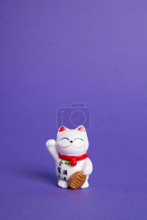Foto de Un gato plástico Maneki-neko, Simbolizando suerte y riqueza, sobre un fondo pop y colorido - Imagen libre de derechos
