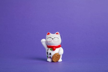 Foto de Un gato plástico Maneki-neko, Simbolizando suerte y riqueza, sobre un fondo pop y colorido - Imagen libre de derechos