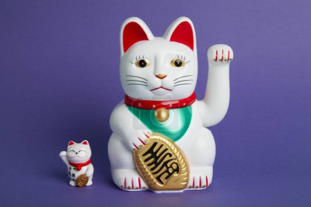 Foto de Una pareja madre y bebé de Maneki-neko gato de plástico, Simbolizando la suerte y la riqueza, sobre un fondo pop y colorido. Mínimo color de moda bodegón fotografía - Imagen libre de derechos