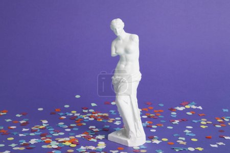 Téléchargez les photos : La venue de Milo entourée de confettis sur un fond violet vif. Fin de la fête. Photographie de nature morte minimaliste et tendance. - en image libre de droit