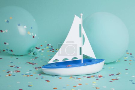 Foto de Un velero navegando un mar de confeti entre globos de iceberg. La composición es de color verde turquesa. Minimalista, fotografía bodegón de moda. - Imagen libre de derechos