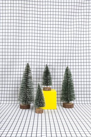 Photo for A miniature forest scene composed of several small christmas trees and a yellow cube on a graphic black and white grid background. minimal still life photography - Royalty Free Image