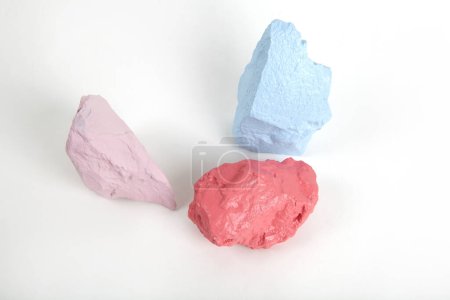 Téléchargez les photos : 3 pierres à peindre ou cailloux dans des tons rose, saumon et pastel bleu isolés sur fond blanc. Nature morte minimale et photographie dynamique - en image libre de droit