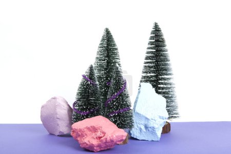 Foto de Bosque en miniatura de árbol de Navidad decorado con mini guirnaldas brillantes. Fondo violeta. Fotografía mínima de naturaleza muerta - Imagen libre de derechos