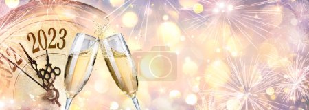 Foto de 2023 - Celebración de Año Nuevo con champán y reloj - Luces Bokeh desenfocadas abstractas - Imagen libre de derechos