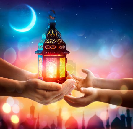 Foto de Mes Santo Musulmán Ramadán Kareem - Dar la mano a Kid linterna árabe que brilla en la noche con luces desenfocadas abstractas - Eid Ul Fitr - Imagen libre de derechos
