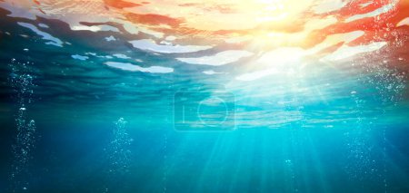 Foto de Océano submarino con puesta de sol - Abismo con luz solar - Fondo desenfocado abstracto y efecto resplandeciente - Imagen libre de derechos