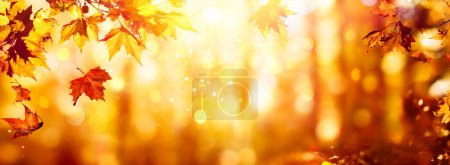 Photo for Autumn - Falling Orange Maple Leaves In Abstract Sunset With Glittering Of Lights - Royalty Free Image