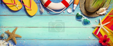 Téléchargez les photos : Beach Summer Arrière-plan - Accessoires Chapeau et serviette avec des sandales et des lunettes de soleil sur planche en bois bleu - en image libre de droit