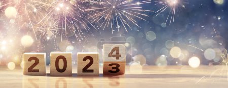 Téléchargez les photos : 2024 Bonne année - Célébration avec des blocs de nombre en bois et des feux d'artifice à Blue Eve Night avec des lumières déconcentrées abstraites Bokeh - en image libre de droit