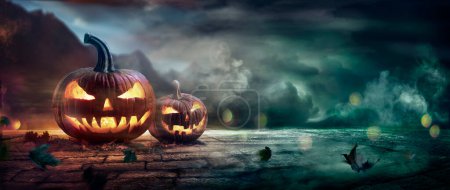 Foto de Calabazas de Halloween en una noche espeluznante con luz desenfocada abstracta y efectos de humo - Imagen libre de derechos