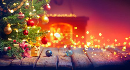 Foto de Regalo bajo el árbol de Navidad con adornos en el interior del hogar con chimenea y luces desenfocadas abstractas - Efectos vintage con algunos efectos de destello de lente - Imagen libre de derechos