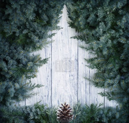 Téléchargez les photos : Concept de Noël - Forme minimale de l'arbre - Branches de sapin sur fond neigeux en bois - en image libre de droit