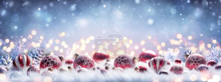 Téléchargez les photos : Décoration de Noël - Boules rouges sur fourrure blanche avec des lumières déconcentrées et fond neigeux abstrait - en image libre de droit