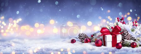 Téléchargez les photos : Boîte cadeau sur la neige avec des lumières de Bokeh et l'ornement dans la branche de sapin Joyeux Noël - en image libre de droit