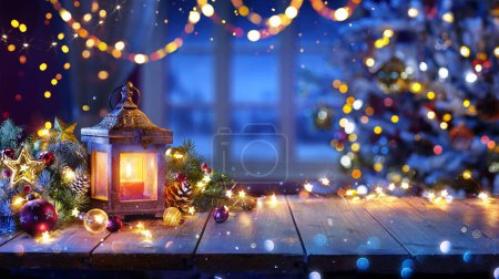 Téléchargez les photos : Lanterne Et Arbre De Noël Brillant Sur La Table Avec Décoration Et Lumières à Chaîne - Bokeh Et Effet Pailletant Sur Le Fond - en image libre de droit