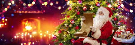 Téléchargez les photos : Père Noël dans sa maison lisant la liste de souhaits - Arbre de Noël et cheminée avec abstraits lumières déconcentrées Bokeh - en image libre de droit