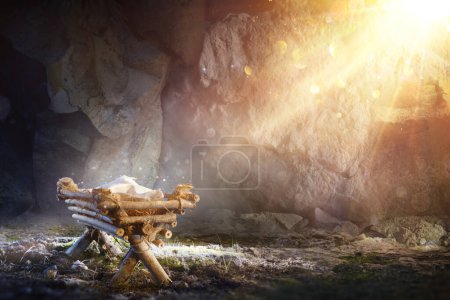 Téléchargez les photos : Nativité - En attendant la naissance de Jésus-Christ avec la colère dans la grotte avec la lumière sainte et abstrait Bokeh déconcentré - en image libre de droit