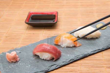 Foto de Atún y sushi de salmón en piedra con salsa de soja - Imagen libre de derechos