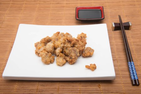 Téléchargez les photos : Plat de poulet au sésame et baguettes sur napperon en bambou - en image libre de droit