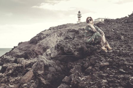 Foto de Elegant mature woman in a coastal area near a lighthouse - Imagen libre de derechos