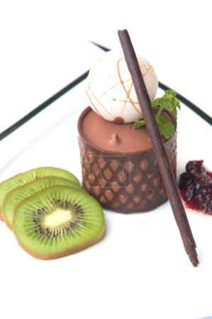 Foto de Chocolate mousse presented with a scoop of ice cream and natural kiwi - Imagen libre de derechos