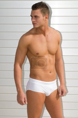 Photo for Attractive and muscular young man dressed. in a very short swimsuit - Royalty Free Image