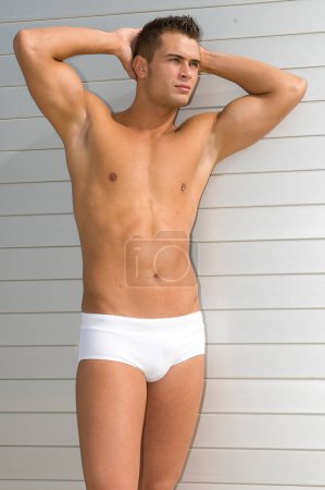 Téléchargez les photos : Attractive and muscular young man dressed. in a very short swimsuit - en image libre de droit