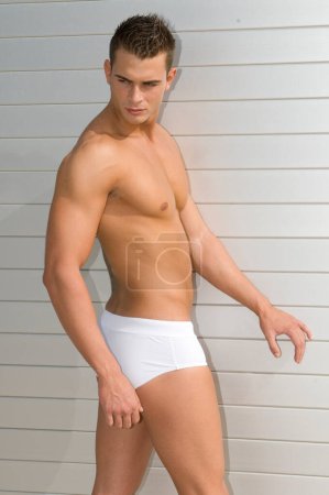 Photo for Attractive and muscular young man dressed. in a very short swimsuit - Royalty Free Image