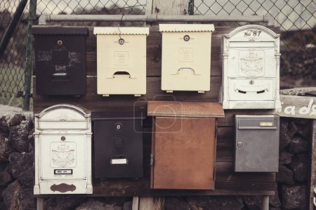 Téléchargez les photos : Des boîtes aux lettres rangées sur une clôture en métal. Style vintage. - en image libre de droit