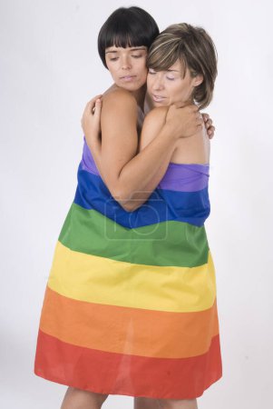 Téléchargez les photos : Couple de femmes en amour avec drapeau arc-en-ciel lesbienne - en image libre de droit