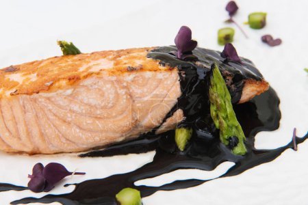 Foto de Filete de salmón con espárragos y vinagre balsámico sobre fondo blanco - Imagen libre de derechos