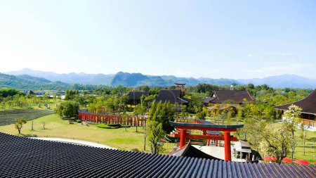 Blick auf atemberaubende Landschaft mit Bergen, grünen Hügeln und japanischem Torii-Tor. Perfekte Natur, Themenpark im asiatischen Stil. Reise, Tourismuskonzept.